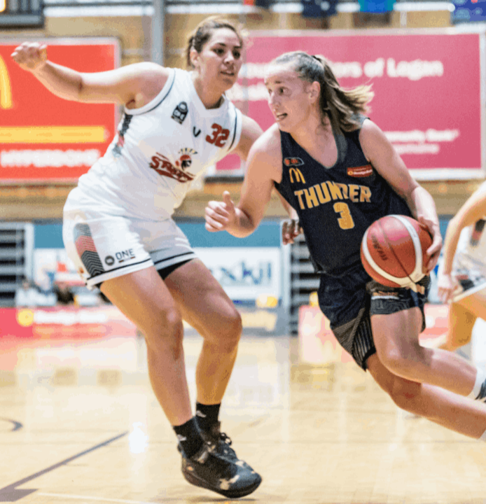 Kalani Purcell playing for Southern Districts Lady Spartans playing defence against Logan Thunder's Mikaela Ruef with the ball.